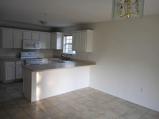 a kitchen with stainless steel appliances granite countertop a sink a stove top oven a counter space and cabinets