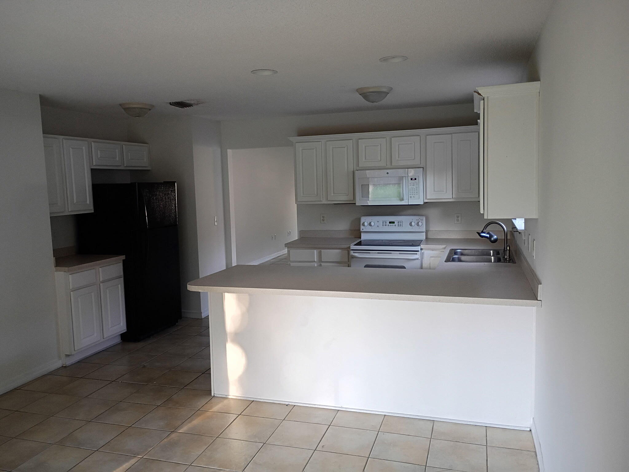 8 Howard Street Niceville, FL 32578 - Photo 4 of 22 a kitchen with kitchen island granite countertop white cabinets and refrigerator