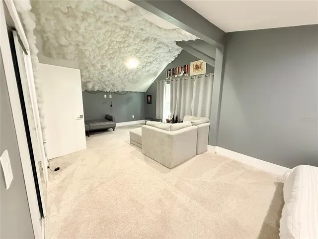 a view of an empty room with wooden floor and windows