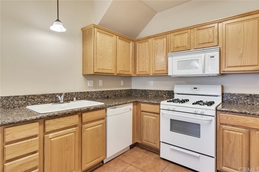 1555 Orange Avenue, Unit 401 Redlands, CA 92373 - Photo 11 of 21 a kitchen with white cabinets and white appliances