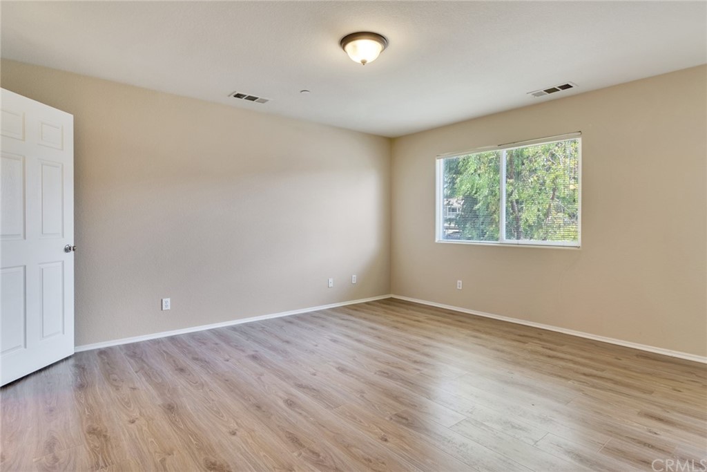 1555 Orange Avenue, Unit 401 Redlands, CA 92373 - Photo 13 of 21 an empty room with wooden floor and windows