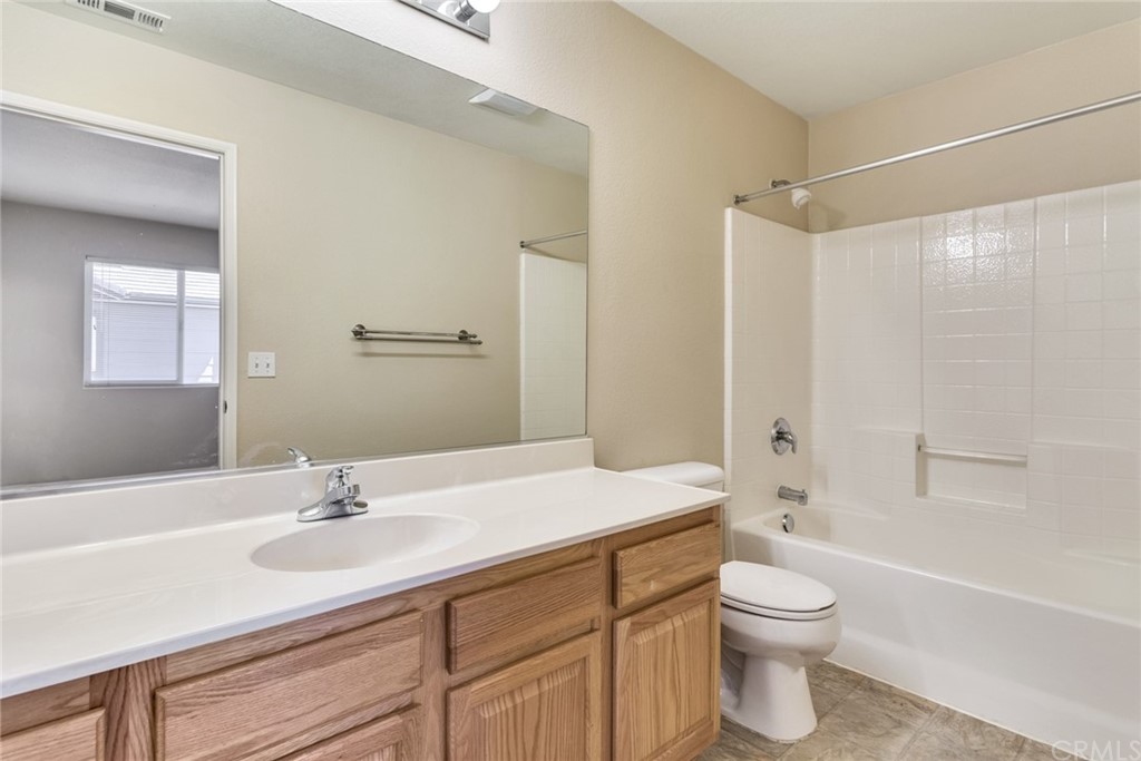 1555 Orange Avenue, Unit 401 Redlands, CA 92373 - Photo 18 of 21 a bathroom with a sink a toilet and a large mirror