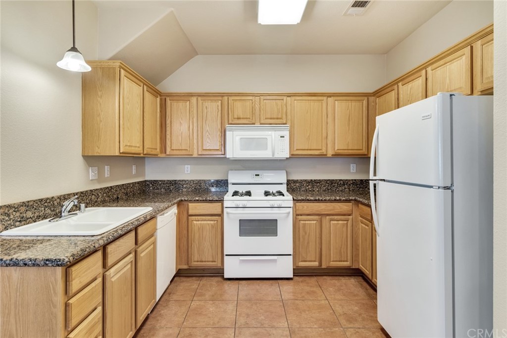 1555 Orange Avenue, Unit 401 Redlands, CA 92373 - Photo 9 of 21 a kitchen with a stove a sink and a refrigerator