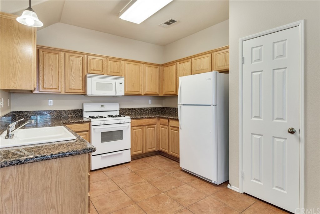 1555 Orange Avenue, Unit 401 Redlands, CA 92373 - Photo 10 of 21 a kitchen with a refrigerator sink stove and cabinets