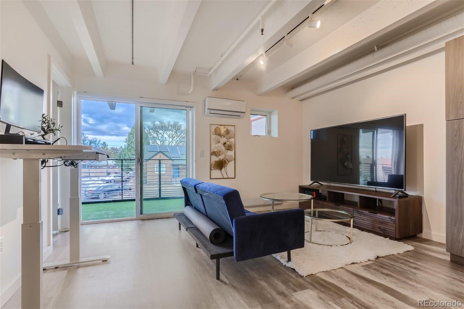 1495 Vrain Street, Unit 218 Denver, CO 80204 - Photo 2 of 5 a living room with furniture and a flat screen tv