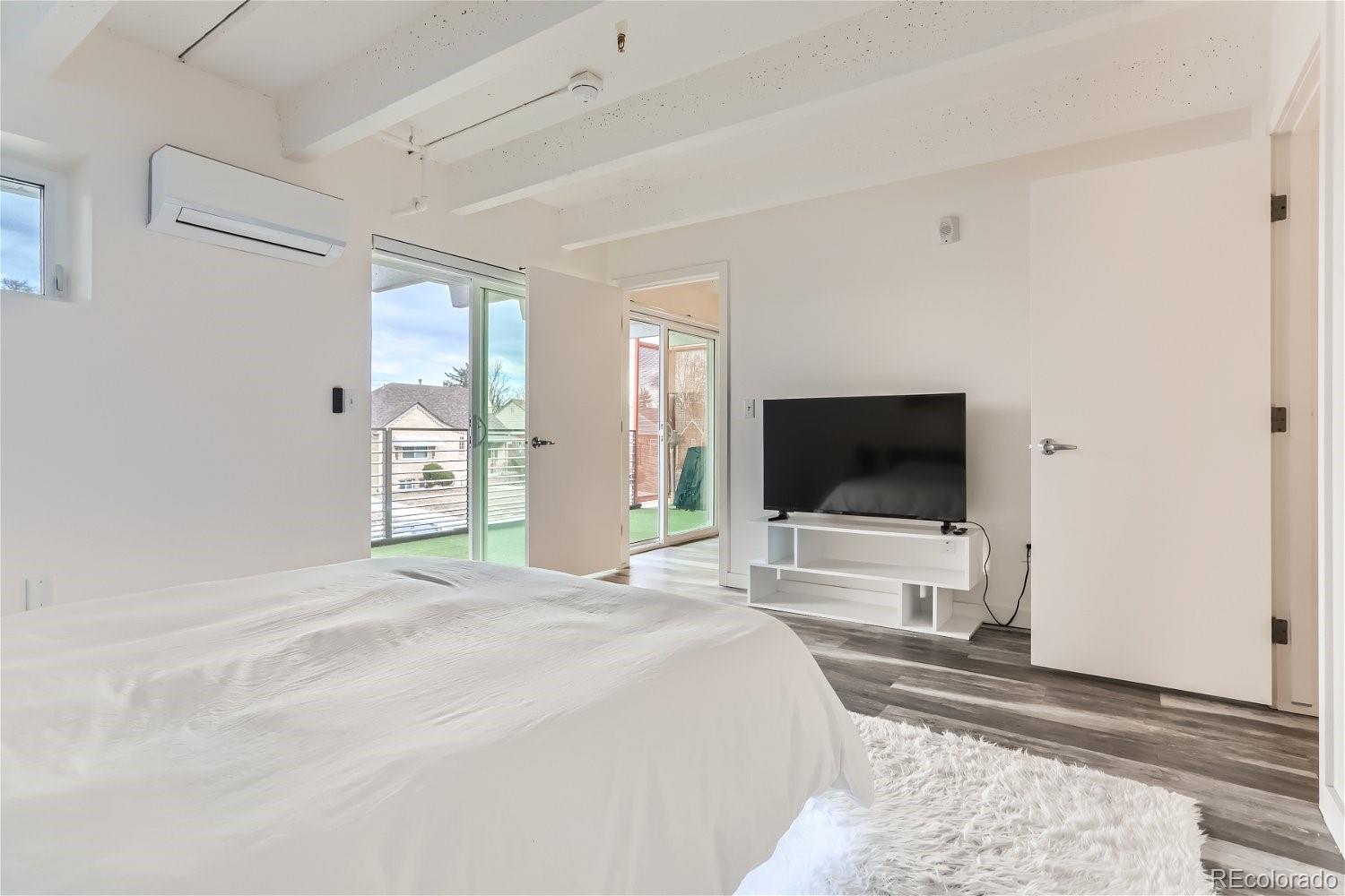 1495 Vrain Street, Unit 218 Denver, CO 80204 - Photo 4 of 5 a bedroom with a bed and a flat tv screen on wall