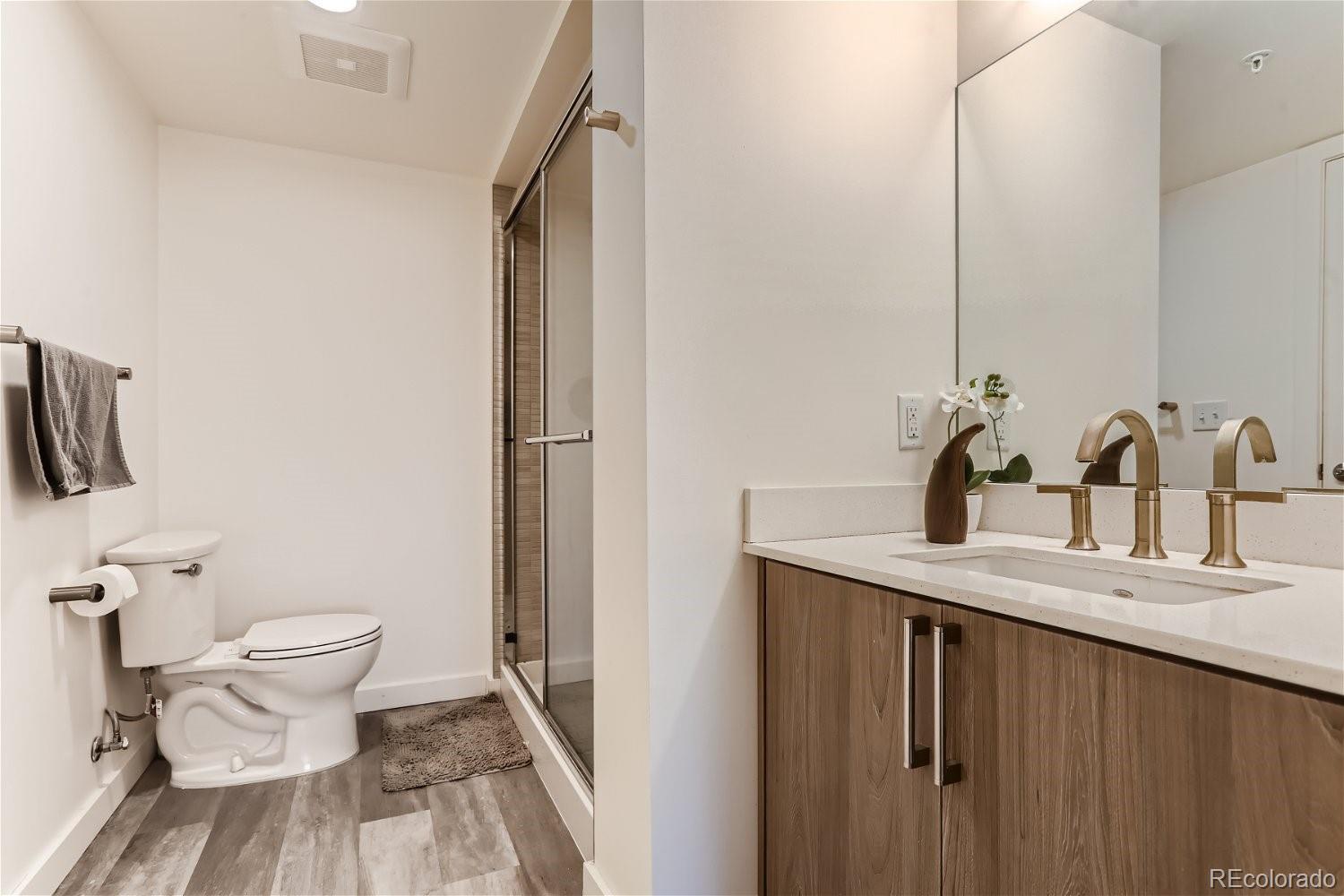 1495 Vrain Street, Unit 218 Denver, CO 80204 - Photo 5 of 5 a bathroom with a granite countertop sink toilet and shower