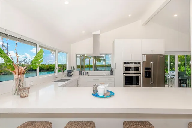a kitchen with furniture and large windows