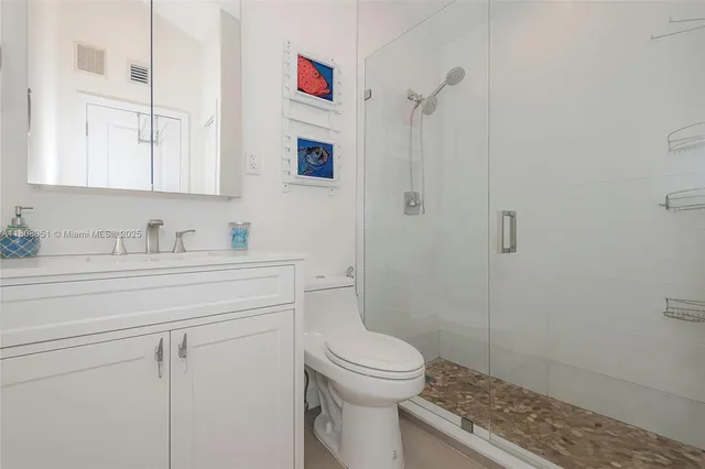 a bathroom with a granite countertop sink a toilet and shower