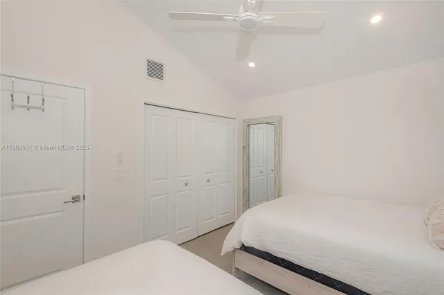 a bedroom with a bed and a chandelier fan