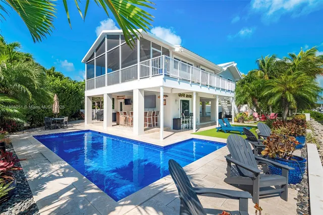 a view of a house with swimming pool and sitting area