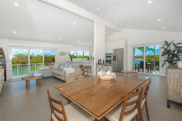 a dining room with furniture and a floor to ceiling window