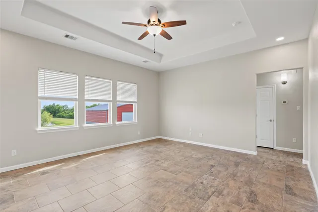 an empty room with windows and fan