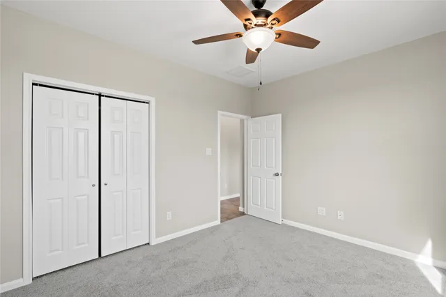 an empty room with a chandelier fan and a ceiling fan