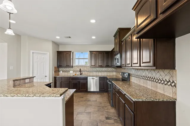 a kitchen with a stove sink and cabinets