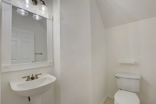 a bathroom with a sink a toilet and mirror