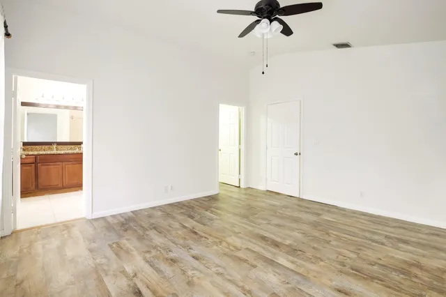 a view of a room with a empty space and a ceiling fan