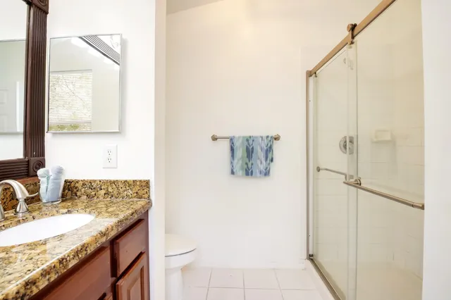 a bathroom with a granite countertop sink and a mirror