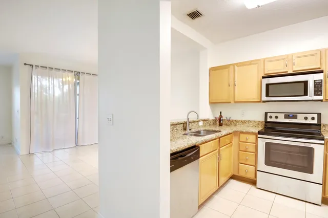 a kitchen with stainless steel appliances granite countertop a sink and a stove