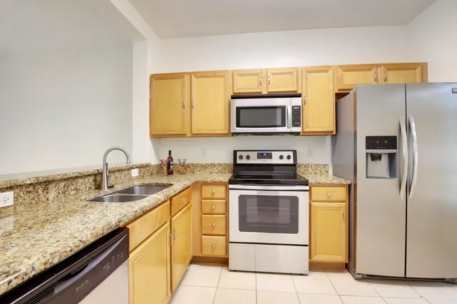 a kitchen with stainless steel appliances granite countertop a stove microwave and refrigerator