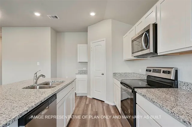 a kitchen with stainless steel appliances granite countertop a sink stove and cabinets