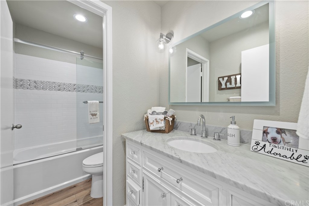 24592 Harbor View Drive, Unit A Dana Point, CA 92629 - Photo 19 of 32 Completely renovated second bath with white a vanity and a marble countertop along with a new bathtub/shower with detailed glass tile along the surround.