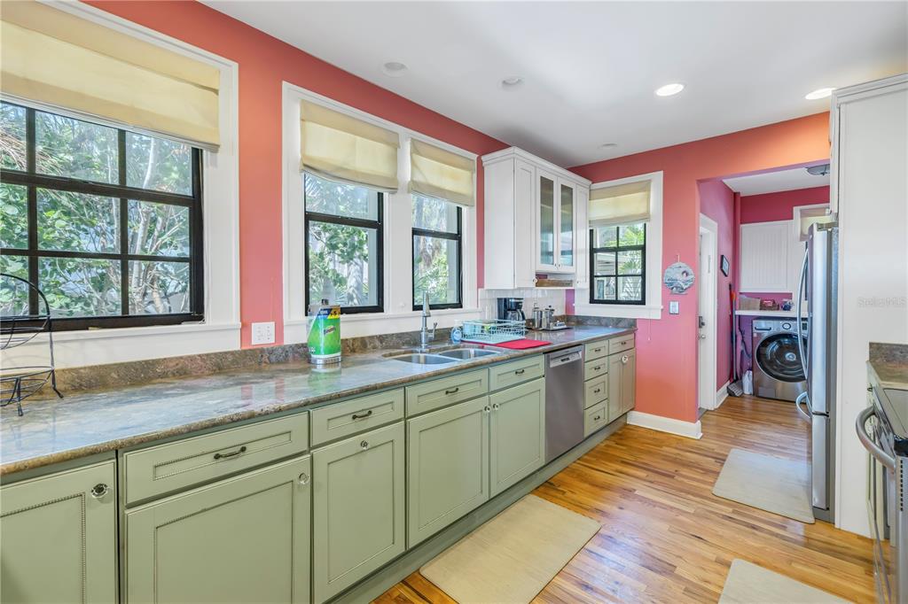 516 Gulf Boulevard Indian Rocks Beach, FL 33785 - Photo 29 of 97 a large kitchen with stainless steel appliances granite countertop a sink and dishwasher with a large window