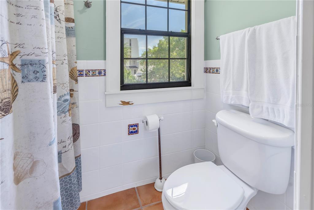 516 Gulf Boulevard Indian Rocks Beach, FL 33785 - Photo 75 of 97 a white toilet sitting next to a bathroom sink and a shower