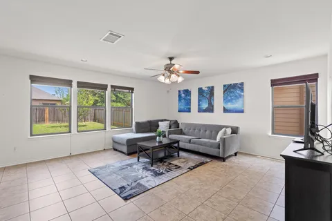 a living room with furniture and floor to ceiling window