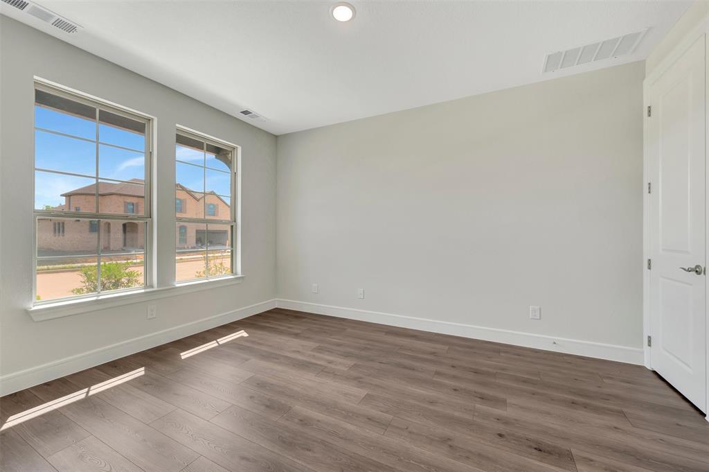 11460 Wulstone Road Fort Worth, TX 76052 - Photo 20 of 40 a view of an empty room with wooden floor and a window
