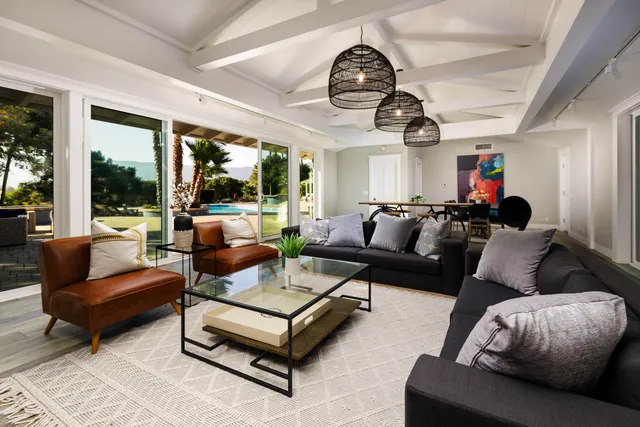 a living room with furniture ceiling fan and a large window