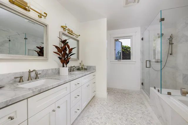 a bathroom with a granite countertop sink mirror and shower