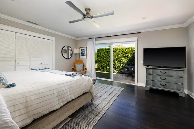 a bedroom with a bed and a flat tv screen on dresser