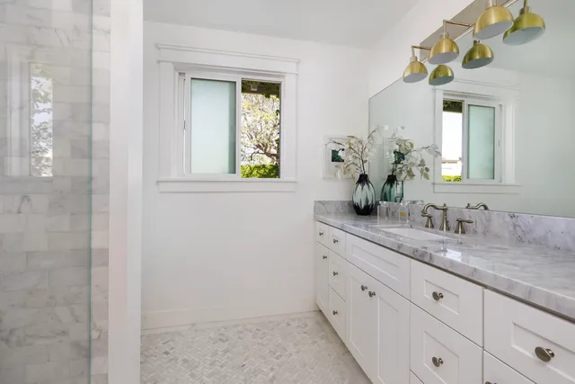 a bathroom with a granite countertop sink and a mirror