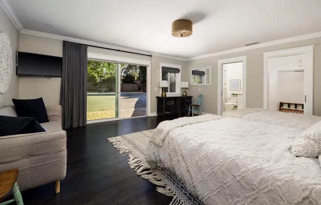 a spacious bedroom with a bed and wooden floor