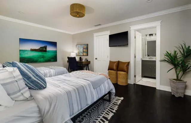 a spacious bedroom with a bed and a flat screen television