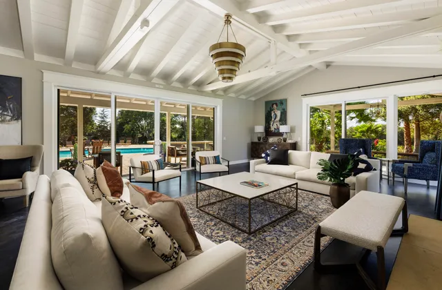 a living room with furniture a chandelier and a large window