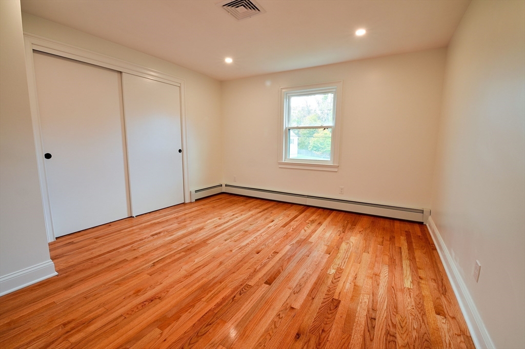 33 Marla Lane Reading, MA 01867 - Photo 19 of 42 an empty room with wooden floor and windows