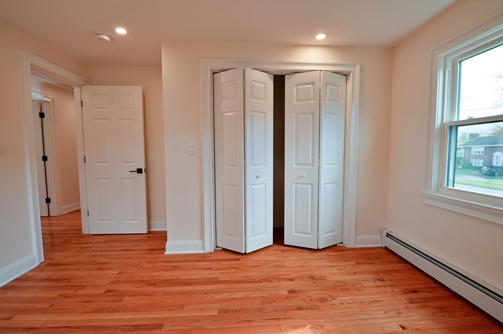 33 Marla Lane Reading, MA 01867 - Photo 20 of 42 a view of an empty room with wooden floor and a window