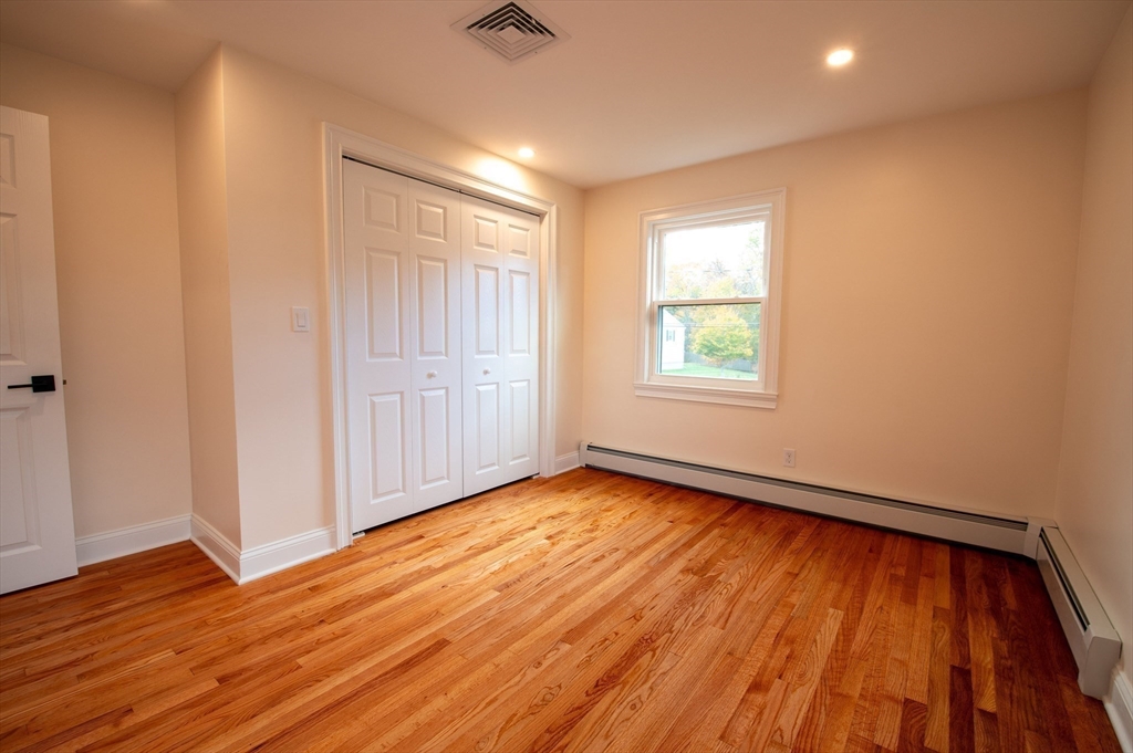 33 Marla Lane Reading, MA 01867 - Photo 21 of 42 an empty room with wooden floor and windows