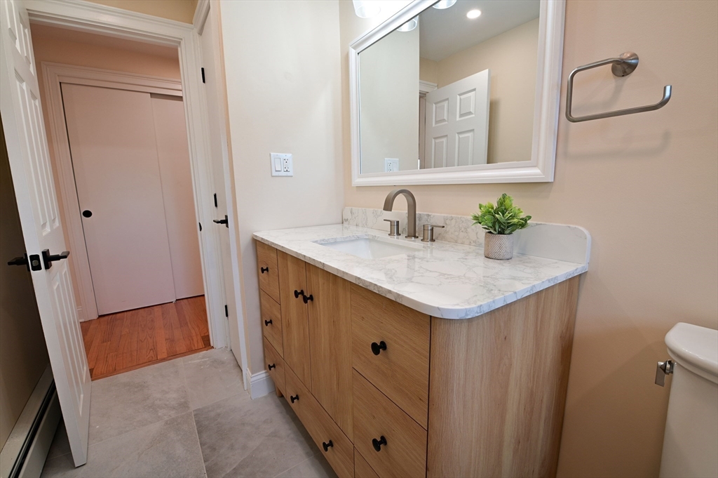 33 Marla Lane Reading, MA 01867 - Photo 24 of 42 a bathroom with a granite countertop sink and a mirror