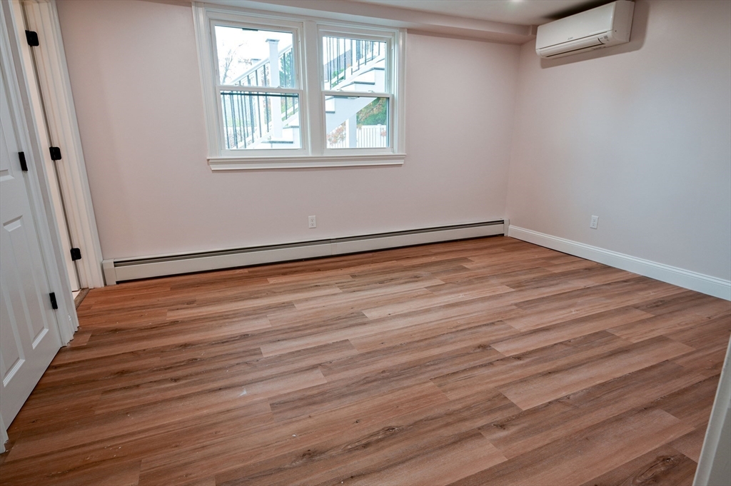 33 Marla Lane Reading, MA 01867 - Photo 31 of 42 a view of an empty room with wooden floor and a window