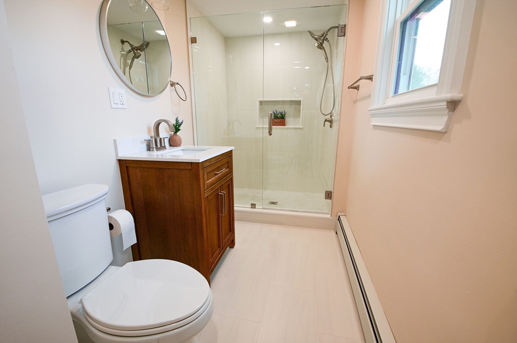33 Marla Lane Reading, MA 01867 - Photo 32 of 42 a bathroom with a toilet a sink and a mirror