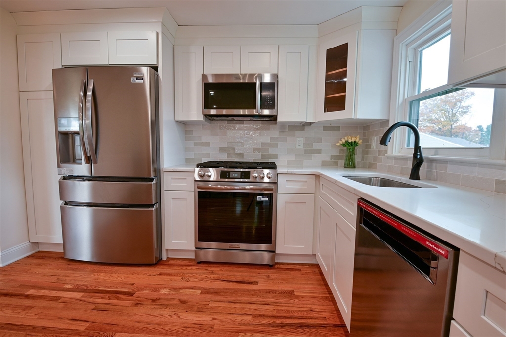 33 Marla Lane Reading, MA 01867 - Photo 6 of 42 a kitchen with stainless steel appliances a refrigerator microwave and sink
