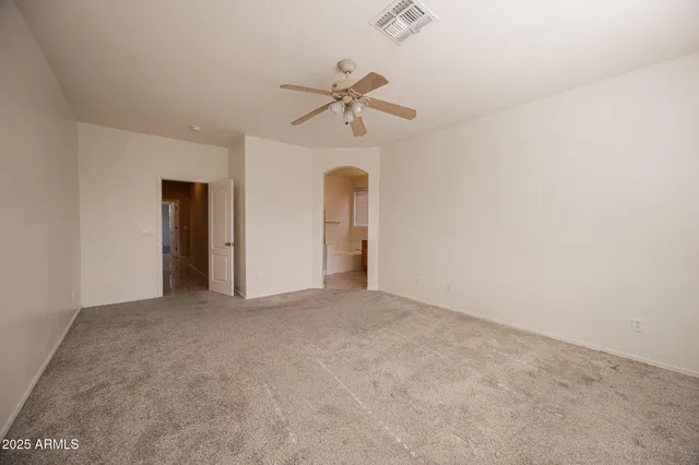 an empty room with a ceiling fan and window