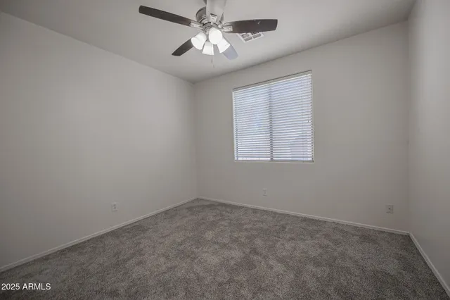 an empty room with a window and a fan