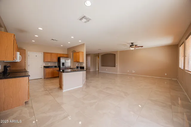 a large kitchen with kitchen island a stove a sink dishwasher and a refrigerator with wooden floor