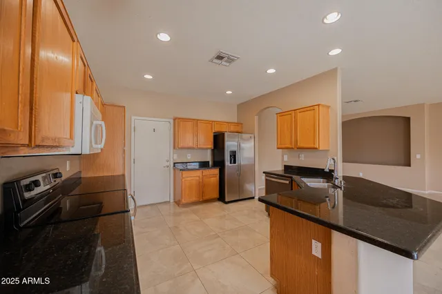 a kitchen with stainless steel appliances granite countertop a sink a stove and a refrigerator