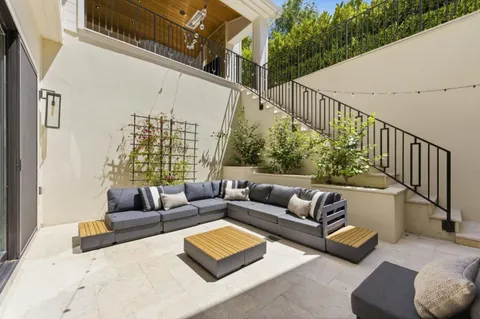 a front view of a house with a yard and potted plants