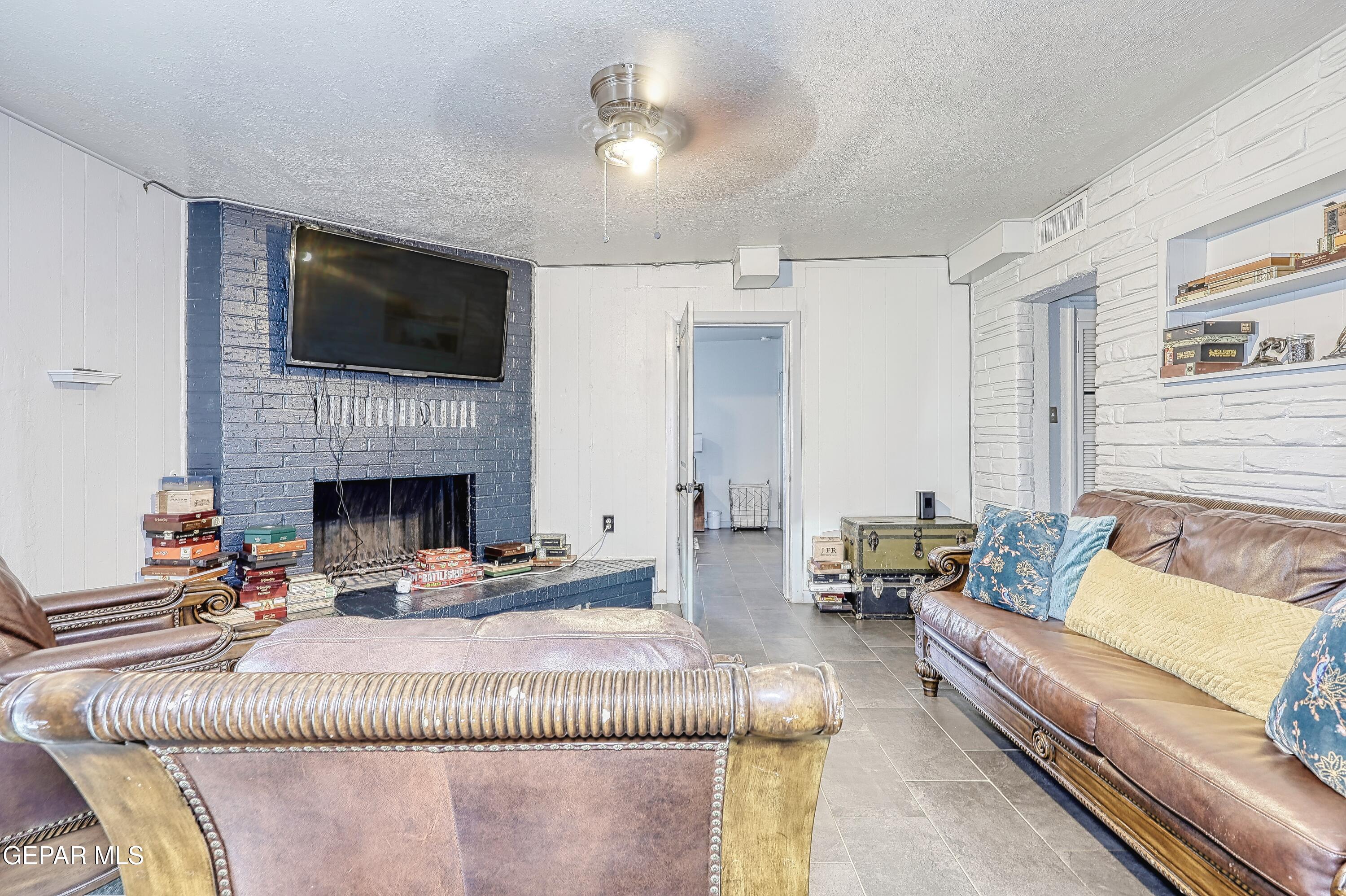 5912 Delta Drive El Paso, TX 79905 - Photo 13 of 37 a living room with furniture a flat screen tv and a fireplace